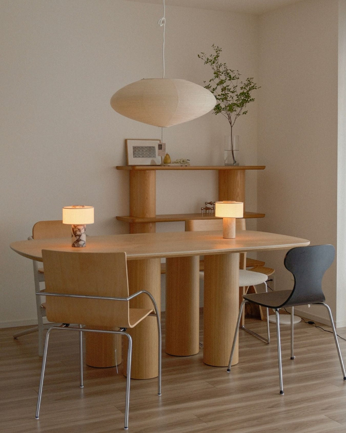 Oriel Travertine Portable Lamp on a dining table with wooden chairs