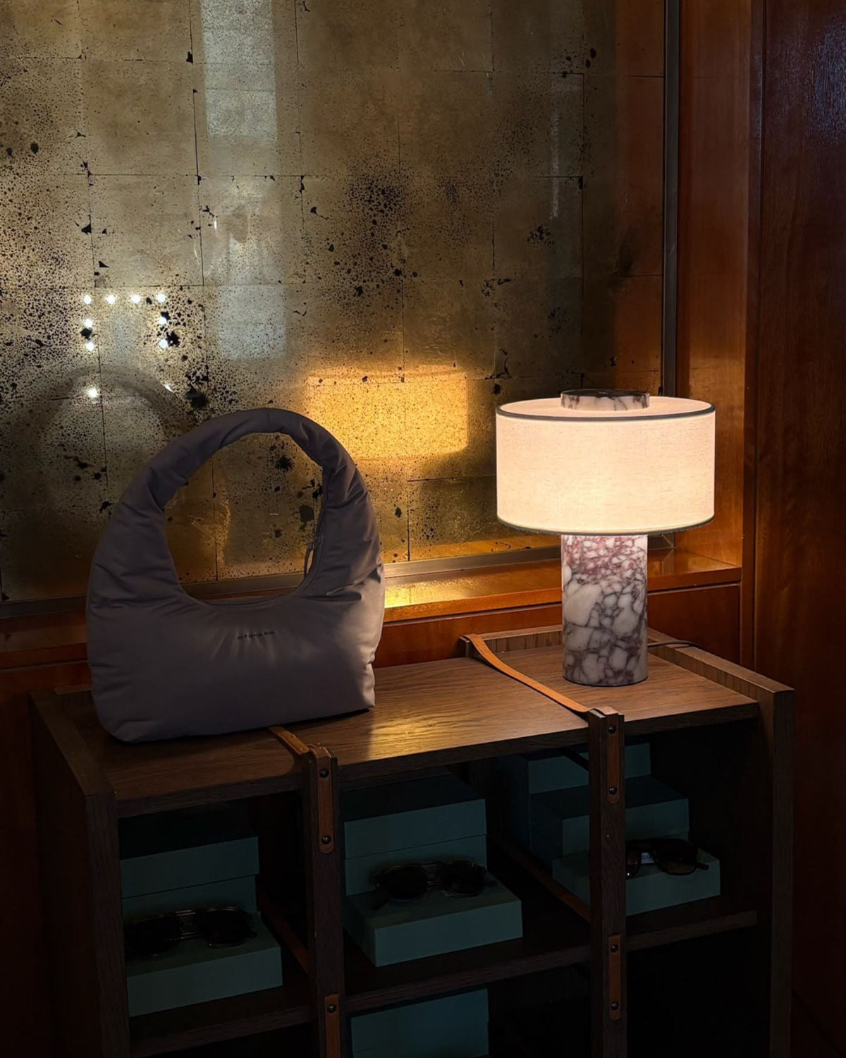 Oriel Calacatta Marble Table Lamp glowing beside a decorative bag