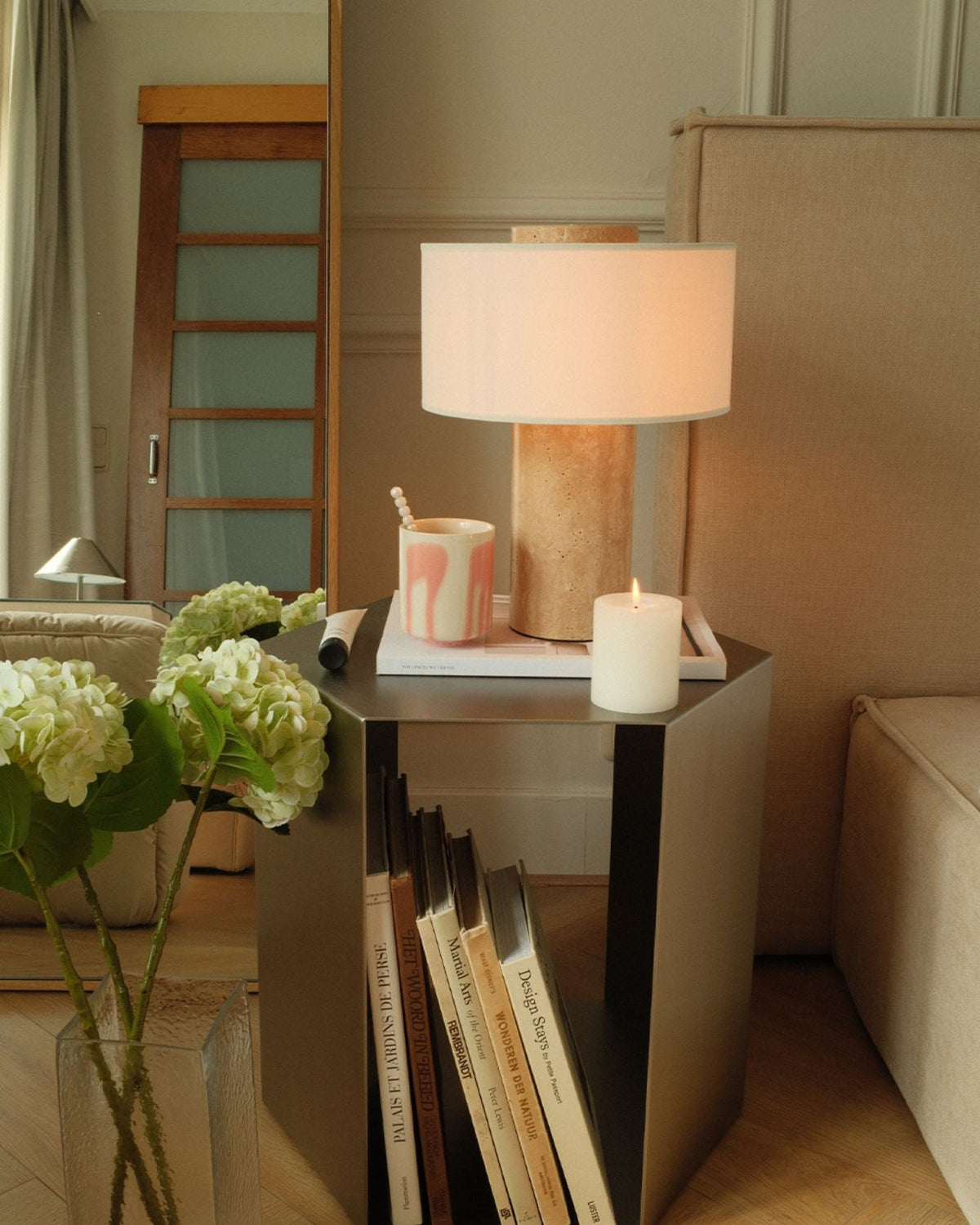 Oriel Travertine Table Lamp beside a bed with flowers and a tray