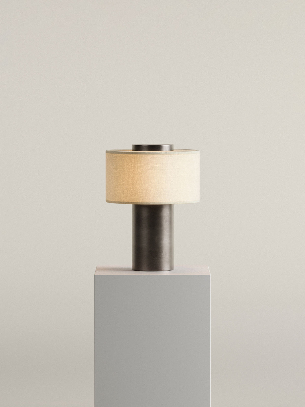 Oriel Bronze Portable Lamp lit on a display plinth