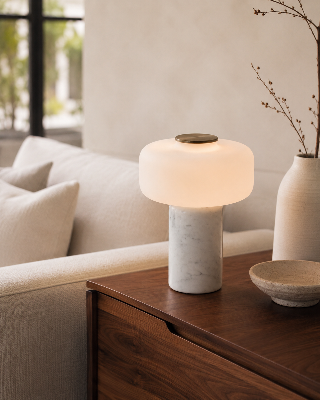 Perrine Sculptural Table Lamp on a side table beside a seat