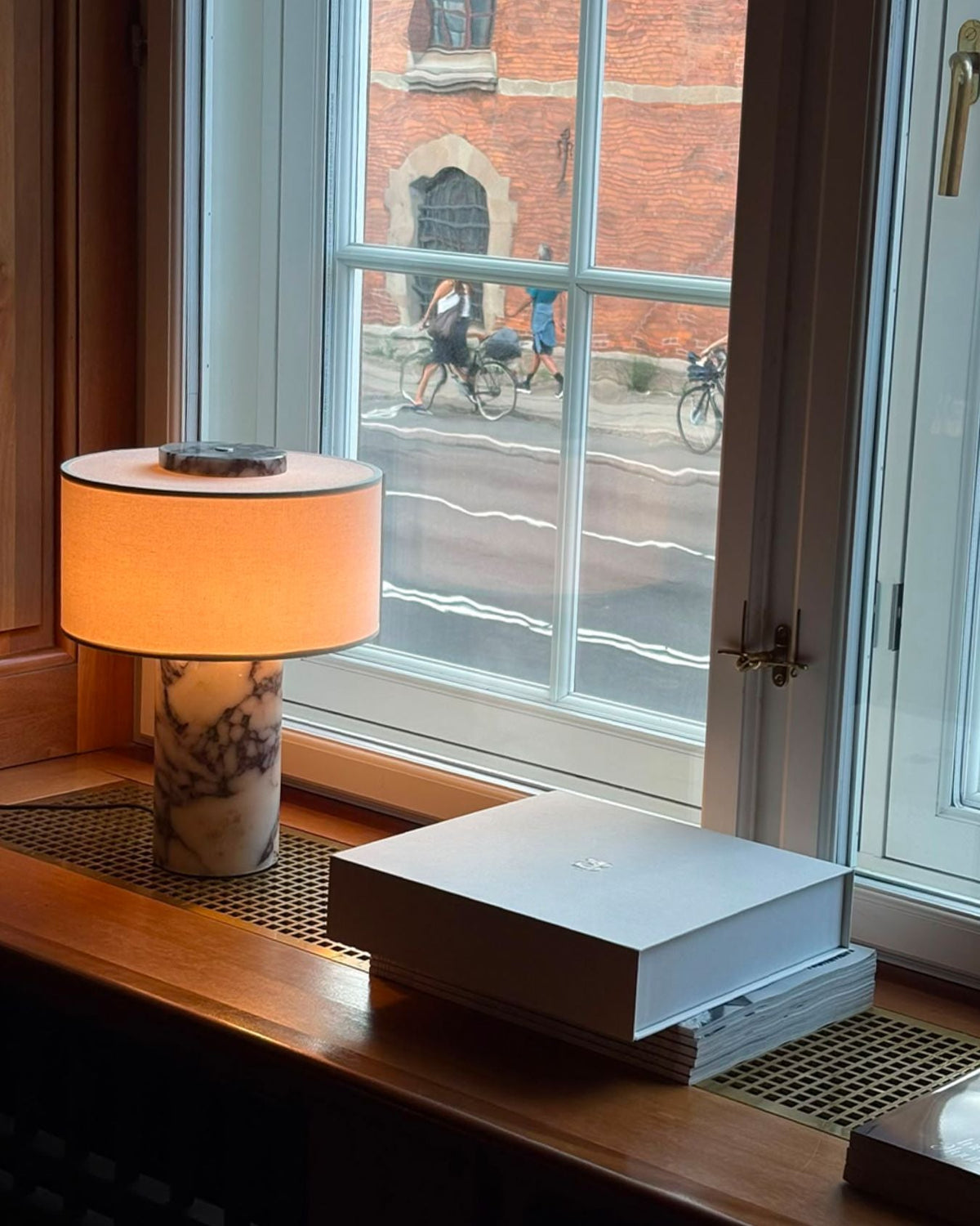 Oriel Calacatta Marble Table Lamp on a desk beside a window