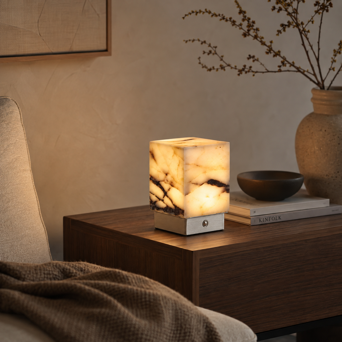 Amara Sculptural Table Lamp on a side table beside a seat