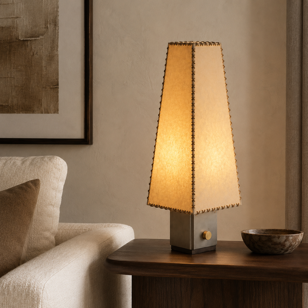 Nyla Sculptural Table Lamp on a side table beside a seat