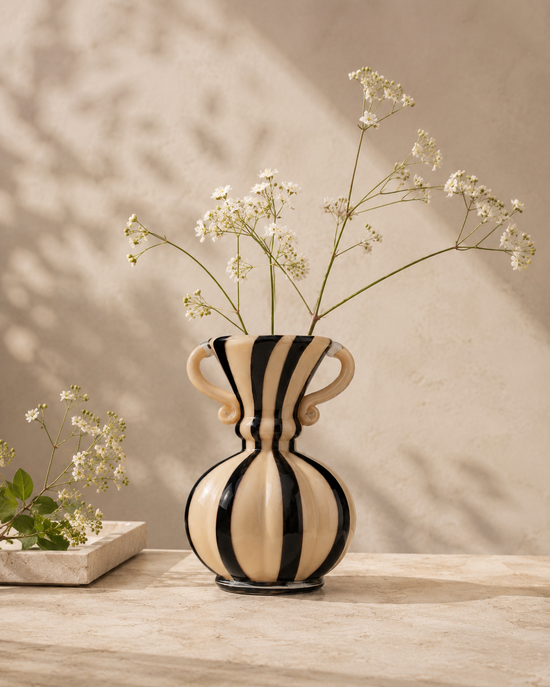 Nela Ribbon Vase with stems on a tabletop
