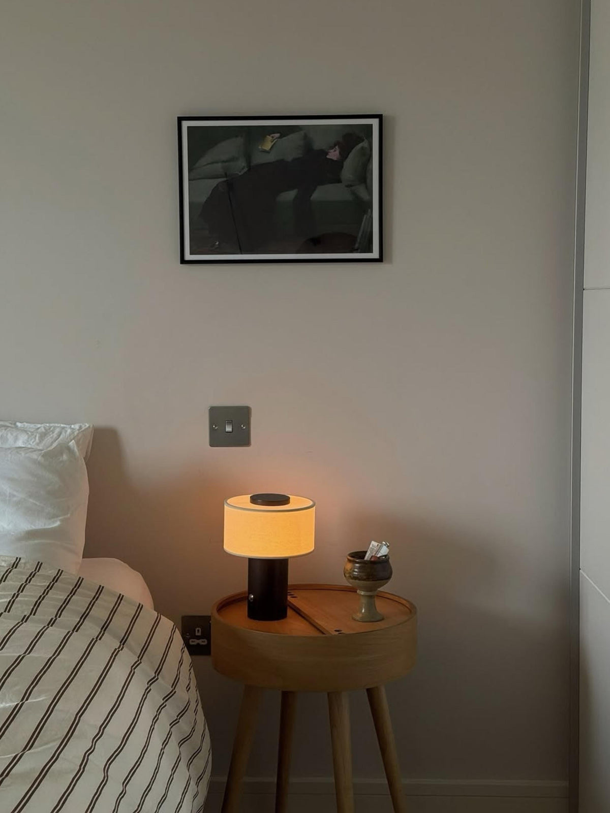 Oriel Bronze Portable Lamp glowing beside a sofa