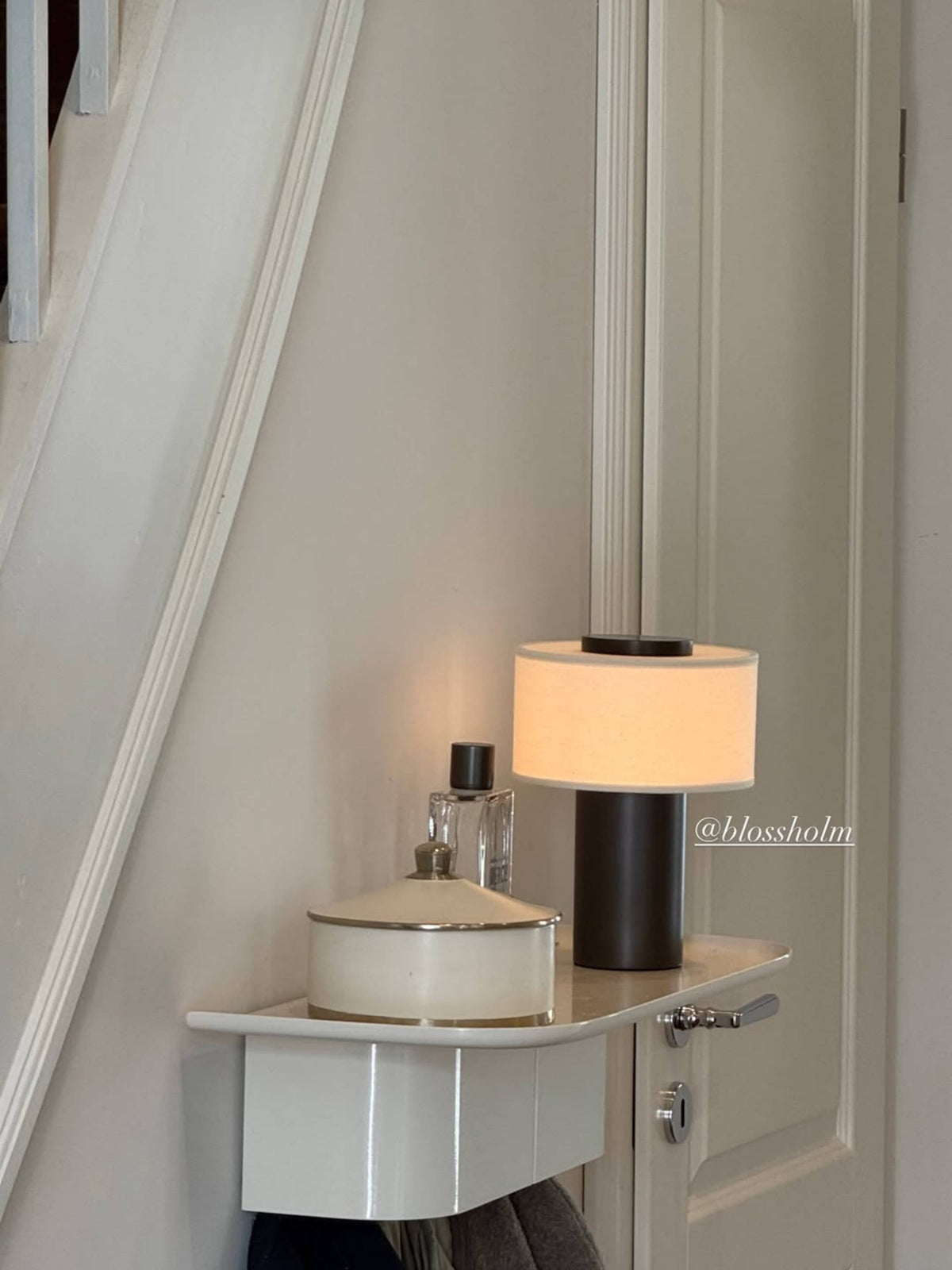 Oriel Bronze Portable Lamp on a round bedside table near a curtain