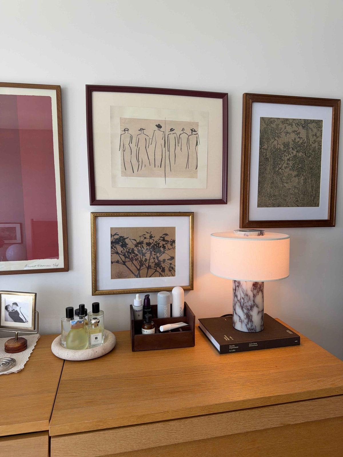 Oriel Calacatta Marble Table Lamp on a wooden cabinet beneath framed art